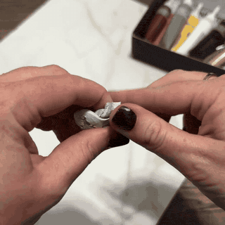 Kneading epoxy tile putty to rebuild a chip or hole